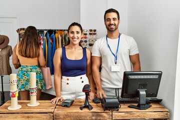 Group of young hispanic people working as manager at retail boutique looking positive and happy standing and smiling with a confident smile showing teeth