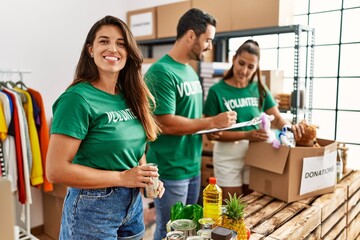 Group of hispanic volunteers smiling happy working at charity center.