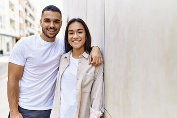 Young latin couple smiling happy and hugging at the city.