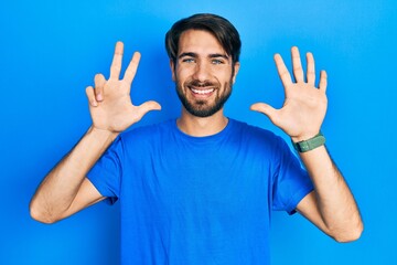 Young hispanic man wearing casual clothes showing and pointing up with fingers number eight while smiling confident and happy.