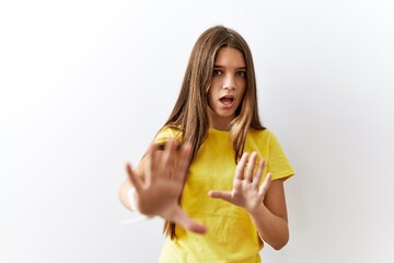 Young brunette teenager standing together over isolated background afraid and terrified with fear expression stop gesture with hands, shouting in shock. panic concept.