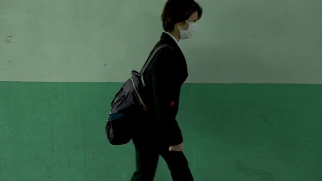 無人の地下通路を歩く女性に近づく不審者