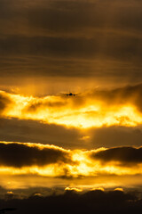 sunset in the clouds, aircraft taking off during golden hour