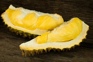 Group of Durian with unshelled seeing the durian with golden ripe meat on wooden background. Durian is the king of fruit and the most famous fruit in Thailand.