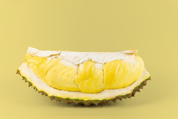 A Durian with golden ripe meat on yellow background.