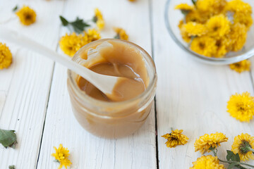 floral fragrant honey on a white wooden table, glass jar with honey

