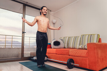 Young man working out exercise jumping the rope at home in the living room