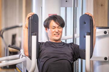 スポーツジムで筋肉を鍛える男性（ストイック）
