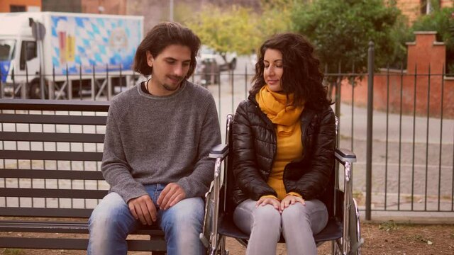 embarrassement, awkwardness - young shy man and his friend with paraplegia look each other shyly