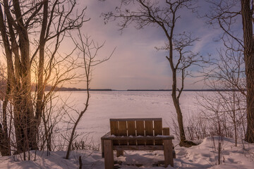 Fototapeta na wymiar Wooden chair by the frozen Ottawa riverside