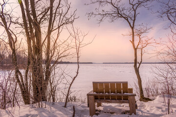 Fototapeta na wymiar Wooden chair by the frozen Ottawa riverside