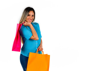 Beautiful young woman looking forward with a happy expression and colorful shopping bags in both hands. Copy space.