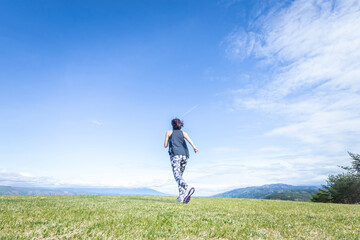 広い場所で運動する女性（走る・後ろ姿）
