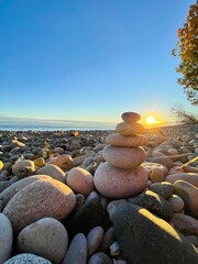 Pile of stones on a beach at sunset 