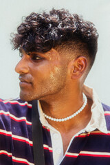 Malaysian Indian men posed in front of a cloth backdrop in a park, sweating