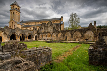 Ruines de l'Abbaye d'Orval en avant-plan du nouvel &eacute;difice sous un ciel gris mena&ccedil;ant