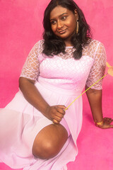 Malaysian Indian individual laughing and posing in a studio setting with a pink background