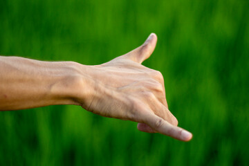 A man's hand and his fingers are being styled shown and blur the background behind it