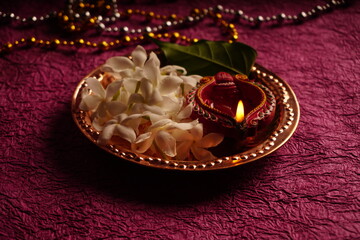 Clay Diya lamps lit with colorful garland during Diwali Celebration. Greetings Card Design Indian Hindu Light Festival called Diwali