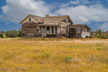 Abandoned home in a farmyard on the prairies near Rush Lake, SK