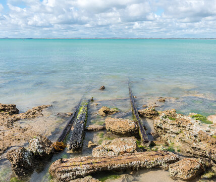 Old Rusty Rails Leading Into The Beach And Blue Waters Of Guichen Bay, On The Limestone Coast At Robe, South Australia