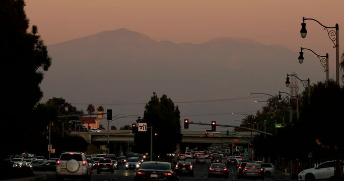 Sunset view of cars passing through the urban core of downtown Rancho Cucamonga, California, USA.