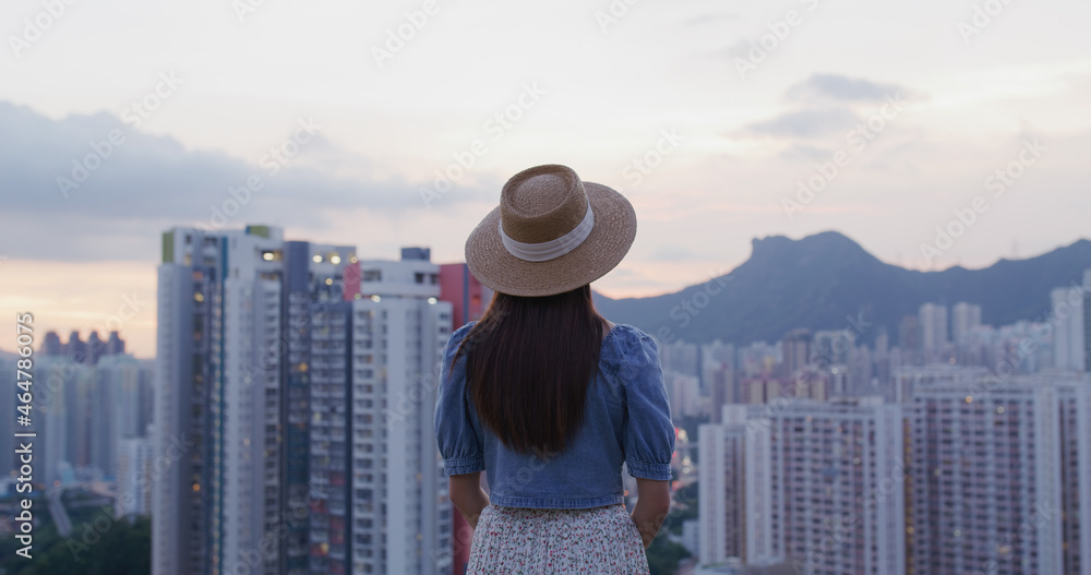 Wall mural Woman look at the city of Hong Kong at sunset