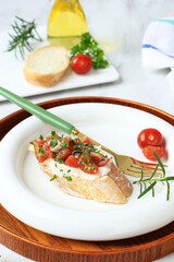 Tomato Ricotta Bruschetta with Fresh Mini Tomatoes Paste, Olive Oil, Brown Bread Baguette, and Rosemarry in a White Ceramic Plate