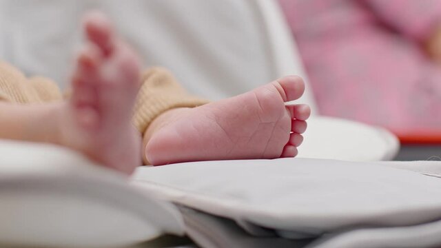 Close up barefoot of newborn baby lying on baby bed relax and comfortable.Infant Baby tiny feet moving on bed at home.Newborn Baby photography concept