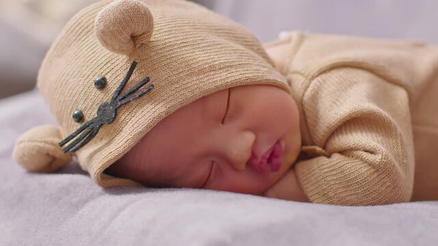 happy newborn baby weaing cute Mouse costume lying sleeps on a grey blanket comfortable and safety.Cute Asian infant sleeping and napping on baby bed.Newborn Baby photography concept