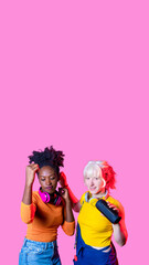 Young diverse black and caucasian women wireless bluetooth speaker dancing together having fun...