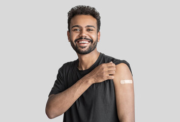 Man smiling after receiving vaccination, young men received a corona vaccine isolated on gray...