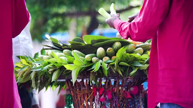 low shot showing a traditional cucumber kakri seller on the street side cutting a fresh organic vegan snack and putting salt on it to eat has a healthy meal