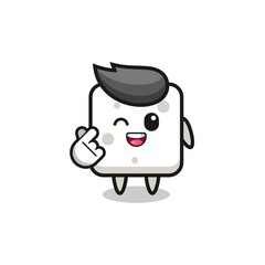 sugar cube character doing Korean finger heart