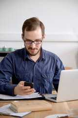 Man using laptop while sitting at wooden table