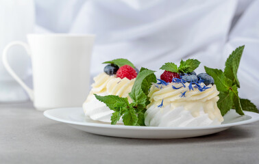 Pavlova dessert with raspberry, blueberry, and mint.