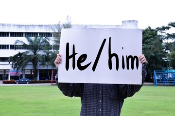 Subject and object pronouns 'He and him' on paper holding in hands of student. concept for English...