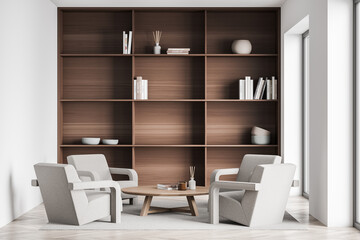Living room with four beige armchairs and dark wood shelving