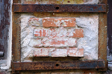 iron frame and brick wall, background. space for text, red brick, old rusty iron, frame, borders. wall with old plaster. retro, vintage background, empty space for lettering