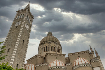 The Parish Church of San Mamante, Lizzano in Belvedere, Italy, under a dramatic sky - obrazy, fototapety, plakaty