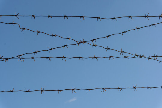 Rusty barbed wire clear blue sky background