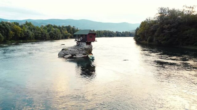 Small wooden cabin on a rock in the middle of river Drina, Serbia.	
