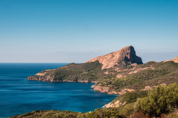 Genoese tower of Tour de Turghiu sitting on Capo Rosso and the rugged west coast of Corsica and the...