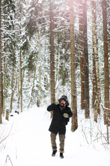 Outdoor portrait of handsome man in coat and scurf. Bearded man in the winter woods.