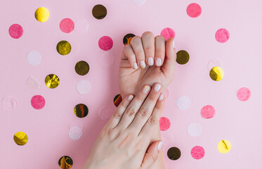 Obraz na płótnie Canvas Stylish trendy female manicure. Female hands on pink festive background.