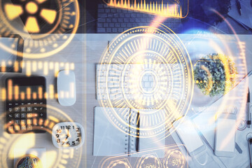 Technology hologram drawing over computer on the desktop background. Top view. Double exposure. Tech concept.