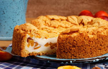 Closeup homemade pie with nectarines on wooden table. Shallow focus.