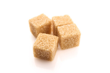 Refined sugar cubes on white background. Brown sugar cubes in background