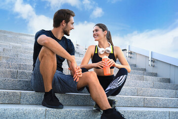 Young couple in sportswear sitting on the stairs after exercising outdoors.