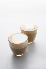 Couple glasses of hot latte coffee on white background